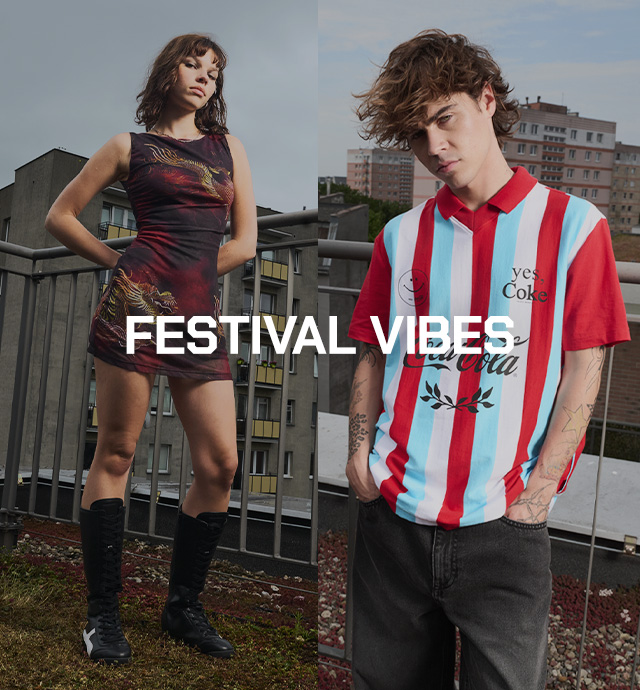 Moteris su aptempta suknele su drakono motyvu ir vyras su dryžuotais Coca-Cola marškinėliais pozuoja ant stogo su miesto panorama, pristatydami „Festival Vibes“ kolekciją. banner